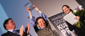 Glückliche Gewinnerin: Sonja Engler von der Zinnschmelze (Mitte) nimmt den Preis von Staatsrat Dr. Carsten Brosda (links) entgegen, rechts daneben die Laudatorin der Jury, die Journalistin Annette Stiekele vom Hamburger Abendblatt.